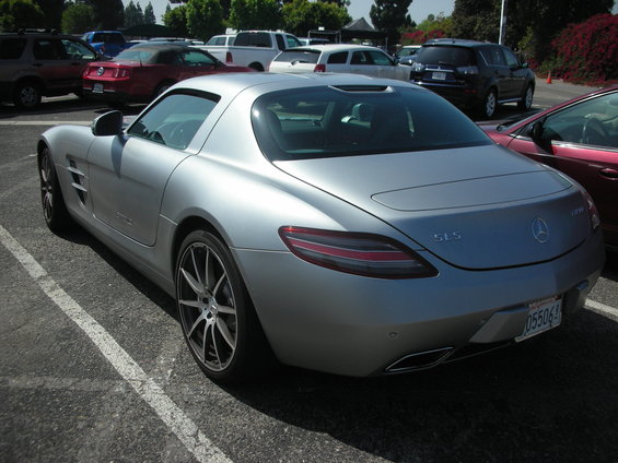 Silver Mercedes-Benz SLS AMG parked in a lot. License plate reads 055064