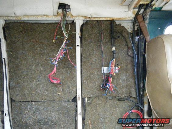 Interior of a van showing exposed insulation and a mess of wires hanging down