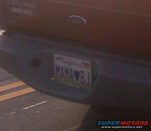 Red Ford Explorer rear bumper with California license plate reading "MAMA BJ" and a heart symbol
