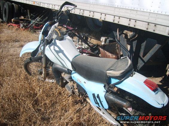 Light blue dirt bike with black seat parked next to a trailer. Number 41 is on the rear fender