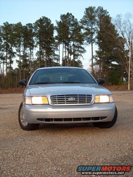 Front view of a silver 2003 Ford Crown Victoria parked on a gravel lot
