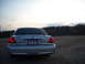 2003 Ford Crown Victoria - The rear of a silver Ford Crown Victoria is shown parked in an open area during the day.