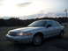 2003 Ford Crown Victoria - A silver 2003 Ford Crown Victoria is parked outdoors under a cloudy sky.
