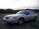 2003 Ford Crown Victoria - Silver 2003 Ford Crown Victoria sedan parked outdoors with trees in the background.