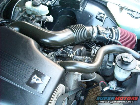 Engine bay with V8 badge and aftermarket air intake
