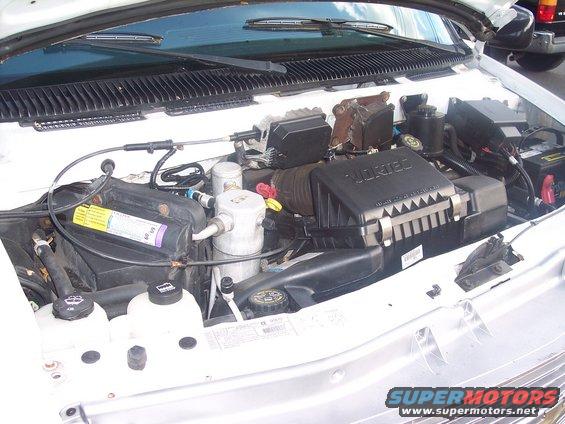 Engine bay with VORTEC air intake, battery, and various hoses and components