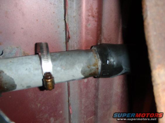 Metal pipe with a hose clamp and a black rubber hose connection