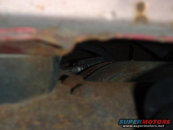 Close-up view of rusty undercarriage and some wiring harness