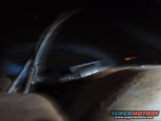 Close-up of a metal part with wires in a dark vehicle interior