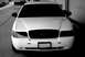 1998 Ford Crown Victoria - Front view of a white 1998 Ford Crown Victoria, a blacked-out grille and tinted headlights.