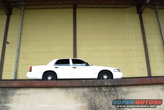 1998 Ford Crown Victoria parked on a ledge against a yellow wall