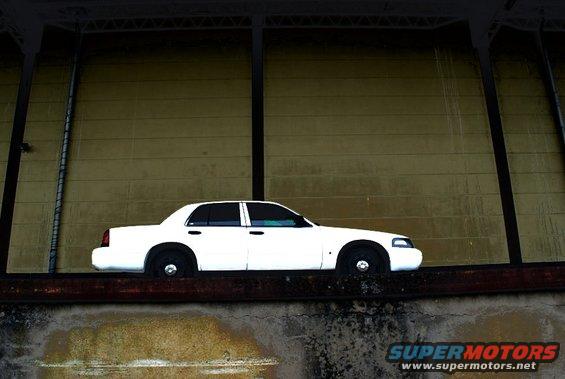 White 1998 Ford Crown Victoria sedan parked on a ledge, side view
