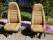1979 Jeep CJ7 - A pair of tan bucket seats, likely from an older vehicle, are displayed outdoors.