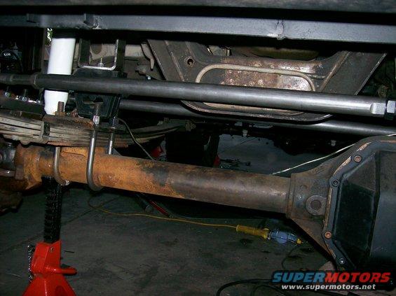 Undercarriage of a vehicle with rusty leaf springs, U-bolts, and a differential housing