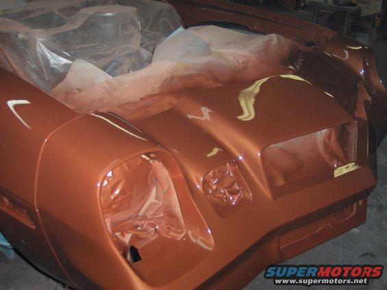 Bronze 1980 Chevrolet Camaro front end being painted, showing hood and fenders