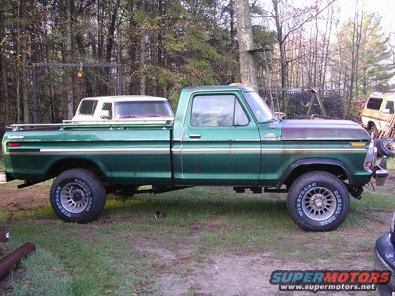Green pickup truck with a white camper shell in the bed. It's a 1975 Ford F-Series