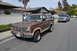 1986 Ford Bronco - A brown Ford Bronco from the 1980s is parked on the street in front of houses, with another truck visible in the background.