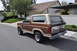 1986 Ford Bronco - 1986 Ford Bronco in two-tone brown and tan, seen from the rear quarter angle.