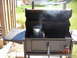 1984 Ford Bronco - A charcoal chimney starter is smoking inside a black grill on a sunny day.