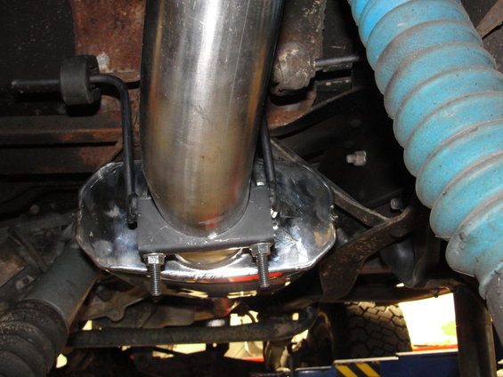 Exhaust pipe clamp with U-bolts on a shiny metal shield