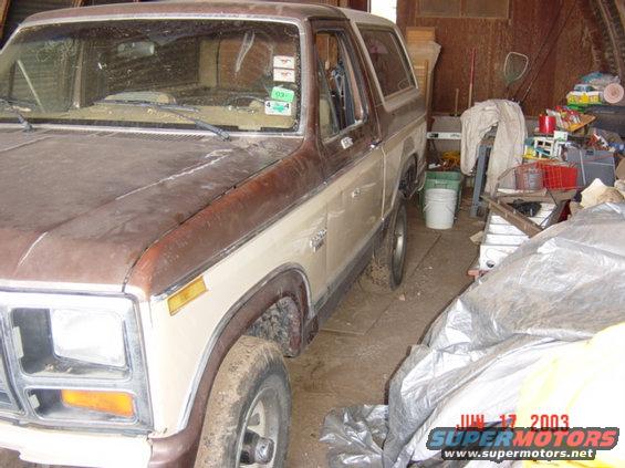 Brown and tan SUV, 3/4 front view, parked in a garage