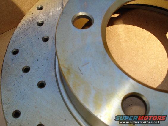 Two stacked metal brake rotors with visible bolt holes and some surface rust