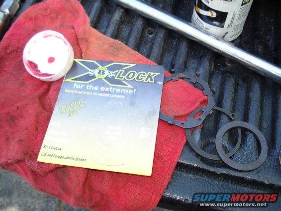 X-LOCK locking spindle nut kit with parts on red cloth