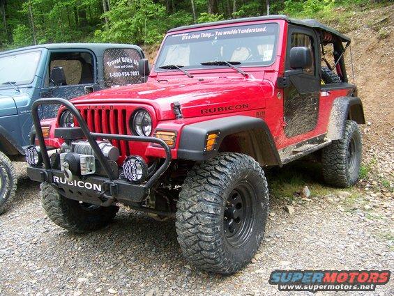 Red Jeep Wrangler Rubicon with winch and off-road tires parked next to a blue Jeep