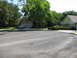 1983 Ford 427 - A silver sedan is parked in the driveway of a suburban home on a sunny day.