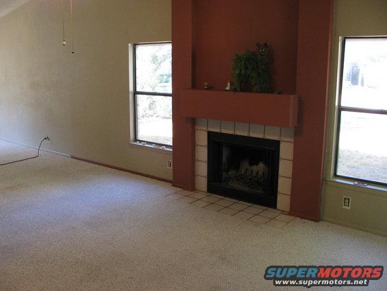 Interior scene with fireplace and two windows