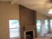 1983 Ford 427 - Interior view of a room a fireplace, vaulted ceiling, and multiple windows overlooking an outdoor scene.