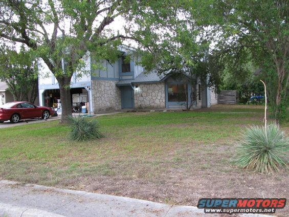 Red coupe parked in driveway, side view