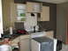 1983 Ford 427 - This photo shows a kitchen area with cabinets, a sink, a stove, and a covered appliance.