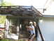 1983 Ford 427 - A man stands by a house with a broken pergola overhead.