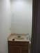 1983 Ford 427 - A bathroom vanity with a sink, countertop, and wooden cabinets is shown, along with a toilet paper holder and a bottle of soap.