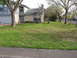 1983 Ford 427 - A suburban house is viewed from the street with a well-maintained lawn and mature trees.