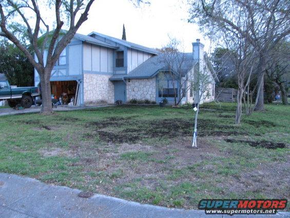 House with a green pickup truck parked in the driveway next to the garage