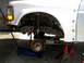 1996 Ford Bronco - Front suspension of a 1996 Ford Bronco, showing the shock absorber and brake rotor, supported by a jack and jack stands.