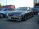 2003 Acura TL - A dark gray sedan is parked in a lot next to other vehicles and a bus.