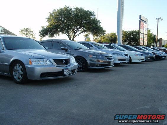 Silver Acura sedan in front of other Acuras parked in a lot