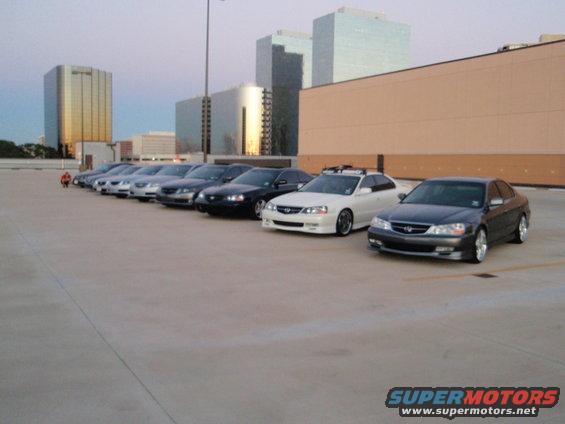 2003 Acura TL and other sedans parked in a lot with buildings in background