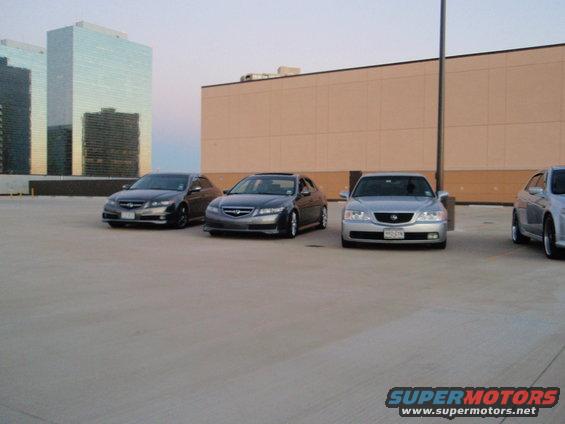 Three dark sedans and one silver sedan parked on a rooftop