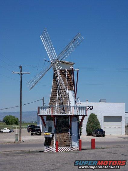 Windmill structure with several vehicles parked nearby