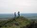 1994 Ford Bronco - Two individuals pause on a hilltop, taking in the expansive view of the rolling green terrain.