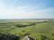 1994 Ford Bronco - A wide expanse of green hills stretches to the horizon under a bright, cloudy sky.