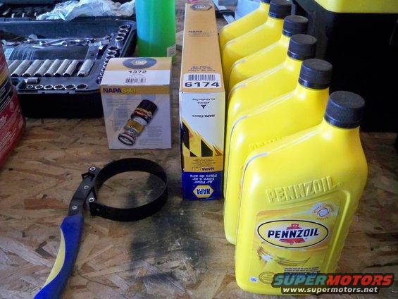 Oil filters, Pennzoil oil bottles, and a filter wrench on a workbench