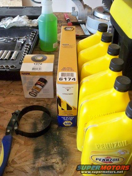 NAPA Gold oil filter, NAPA air filter, Pennzoil oil bottles, and a filter wrench on a workbench
