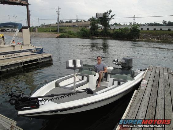Guy sitting in a bass boat docked next to a pontoon boat