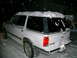 1994 Ford Explorer - A white 1995 Ford Explorer SUV is parked outside during a snowfall, with snow accumulating on its roof and rear.