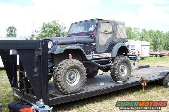 Jeep CJ-7 on a flatbed trailer, with a soft top and off-road tires